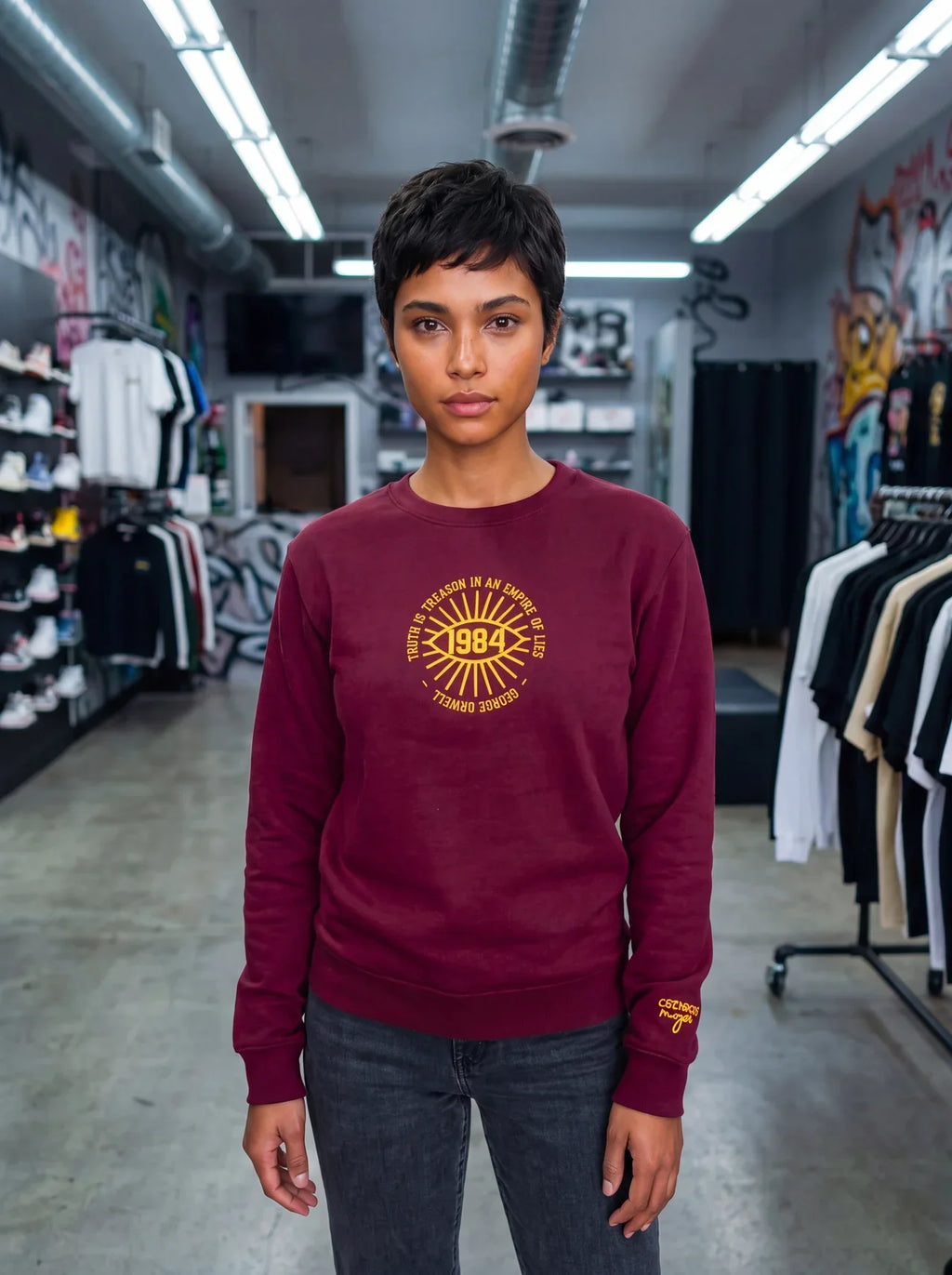 Model wearing the Truth is treason embroidered sweatshirt in Maroon, sneaker store